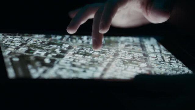 Person rotating satellite view map using fingers on a tablet. Close up, slow motion. 
