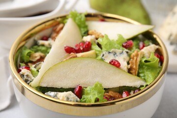 Delicious pear salad in bowl on table, closeup