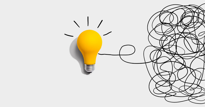 Clarifying complex ideas theme with light bulb - Flat lay