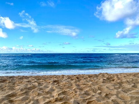 Sandy beach with ocean and blue sky