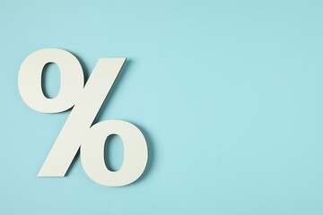 White percent sign on light blue background, top view. Space for text