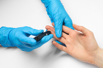 Obraz premium Diabetes. glucose testing. Doctor using lancet pen on white background, closeup