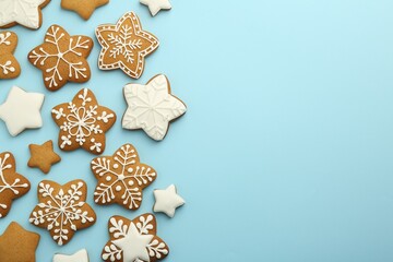Tasty star shaped Christmas cookies with icing on light blue background, flat lay. Space for text