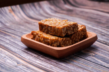 Fototapeta na wymiar Fried tempeh in a container on a wooden table