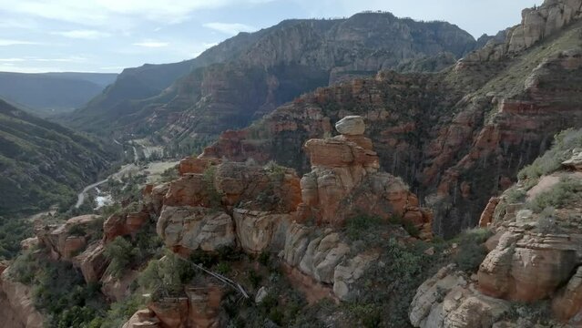 Red rock mountains and buttes in Sedona, Arizona with drone video moving in close up by stones.