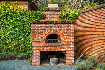 Old red brick stove outside.