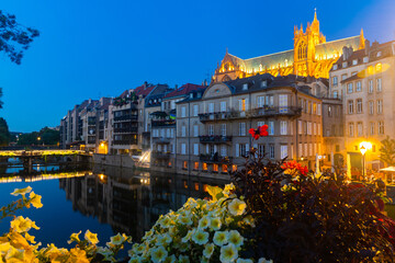 Scenic nighttime view of summer Metz cityscape overlooking illuminated majestic Gothic Roman...