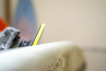 Electric disc polishing the surface of a surfboard