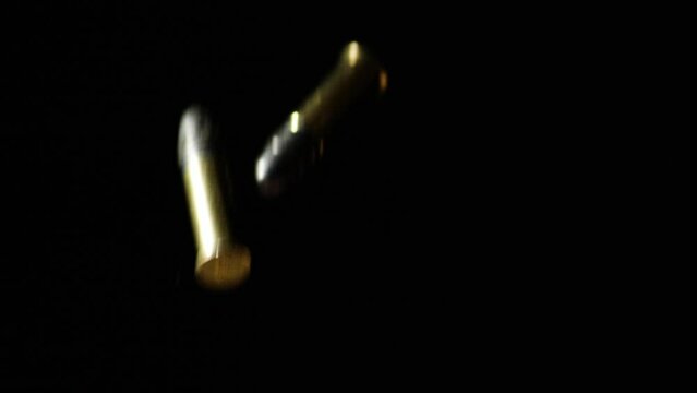 9mm Parabellum Firearm Cartridges Falling Against Black Background. - closeup shot