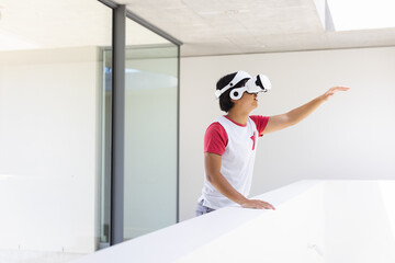 Teenage Asian boy explores virtual reality at home, with copy space