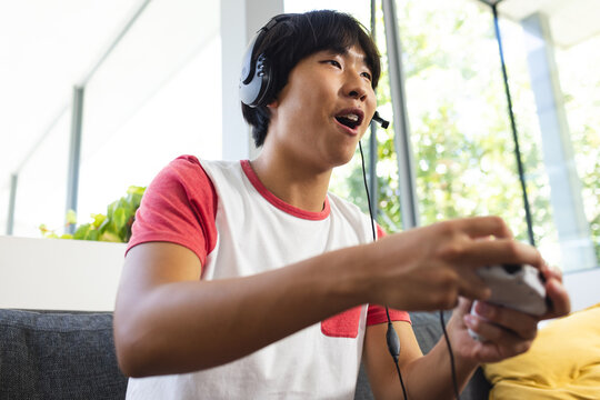 Teenage Asian boy enjoys a gaming session at home