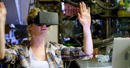 Image of white markers moving over woman wearing vr headset and moving her hands