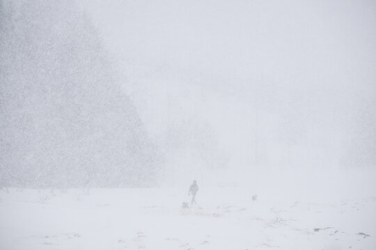 Silhouette of unrecognizable person walking on snowy terrain