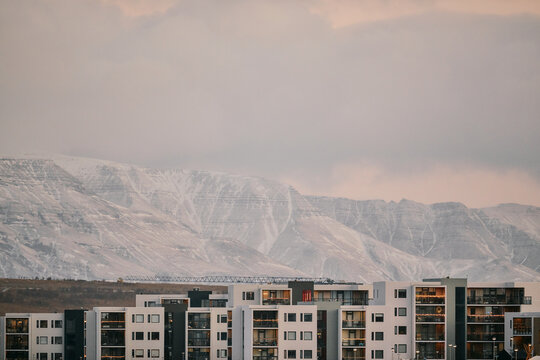 Amazing view of snowy mountains behind residential apartments in city