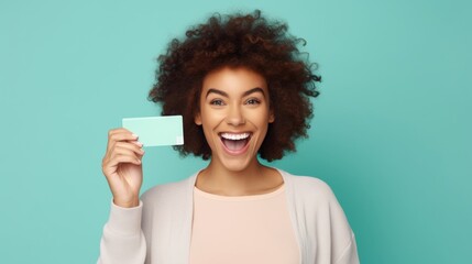 Cheerful African American woman with a card, vibrant backdrop