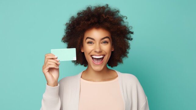 Cheerful African American woman with a card, vibrant backdrop