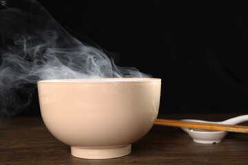 Smoke vape fog rising flowing out of miso soup black red white bowl on dark black background - 736742819