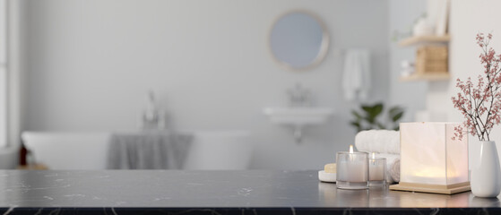 A copy space on a black marble countertop with toiletries in a modern white and clean bathroom.