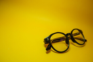Stylish eyeglasses in black frames on a yellow background. Short sighted and presbyopia...