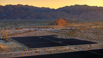 Section of solar panels with Crocodile Mountain in the background and illuminated by sunset