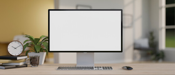 A computer mockup with decor on a minimal wood table in a modern office room.
