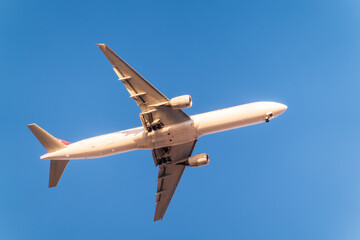 Fototapeta na wymiar Airplane before landing in blue sky, Airbus A330