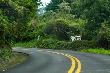 Cenotafios populares en medio de vegetación a orillas de la curva de una carretera en Mexico