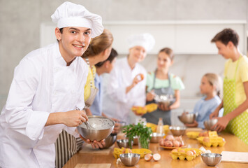 Young guy cook posing with dishes at cooking master class
