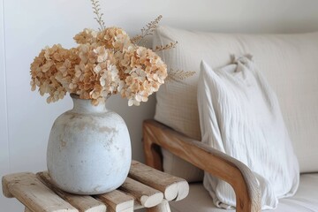 A sophisticated composition with dried hydrangeas in a textured pottery vase set against a clean, white background