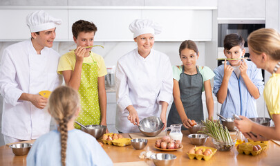 Teenage children are interested in learning in culinary courses under the supervision of two adult...