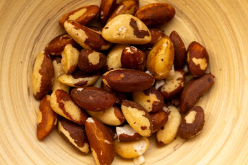 Brazil nuts in a bamboo bowl, top view.