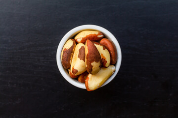 Brazil Nuts in a bowl on a black background.