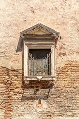 Vintage Window with Iron Grate on Weathered Brick Wall