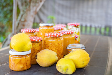 A table adorned with jars of homemade jam and fresh lemons, showcasing natural foods and...