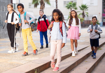 Schoolchildren walking together on the street from school outdoors