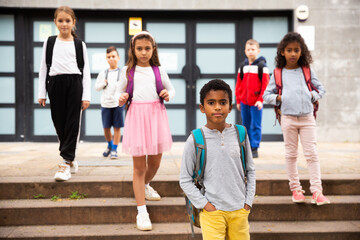 Obraz premium Preteen boy with rucksack walking outdoors on his way to school on warm autumn day. Back to school concept.
