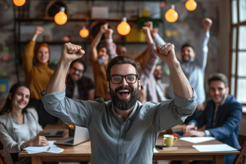 Happy and successful businessman raising his fists in celebration of good news at his office. Expression of victory and success at work, his team on background - obrazy, fototapety, plakaty
