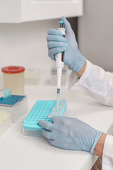 Close up of scientist is using micropipette for biochemical test analysis in medical laboratory