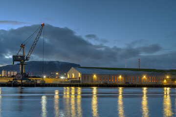 A loading crane and a storehouse in the port of Belfast at dusk