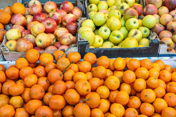 Naklejka na ściany i meble Tangerines and apples for sale at a market