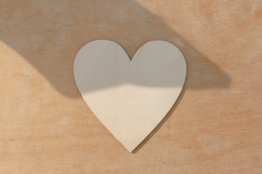 Photo of wooden heart design, showing empty space with sunlight.