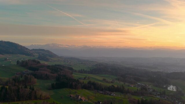 Drone flight over a hilly landscape at sunset in the canton of Z&uuml;rich