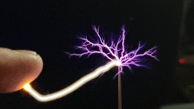 Science experiment electricity discharge sparks contact with finger close to Tesla voltage generator