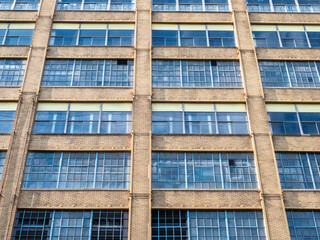 Obraz premium An Old Historic Factory With Large Windows and A Brick Facade With Multiple Stories