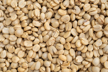 Unroasted green Arabica coffee beans flat surface. Backgrounds. Closeup macro food photo directly...