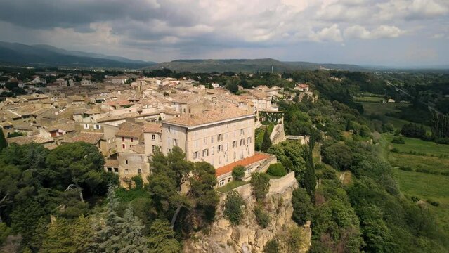 Aerial rising shot revealing the Lauris commune on a cliff in France