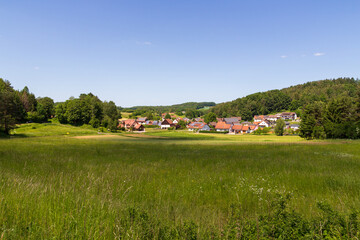 Fototapeta na wymiar Rural scene with hill panorama, meadows and houses of village Bärnfels near Obertrubach in Franconian Switzerland, Germany