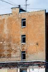 A fragment of a dilapidated building wall on a winter day