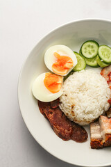 Red Pork and Crispy Pork on Rice Served with Chinese sausage, cucumber, boiled egg. and boiled bone soup, red pork and crispy pork on rice It is a popular food in Thailand.