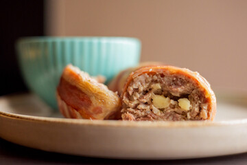 savory delight: delicious dish with meatballs wrapped in bacon, filled with mozzarella and yogurt sauce